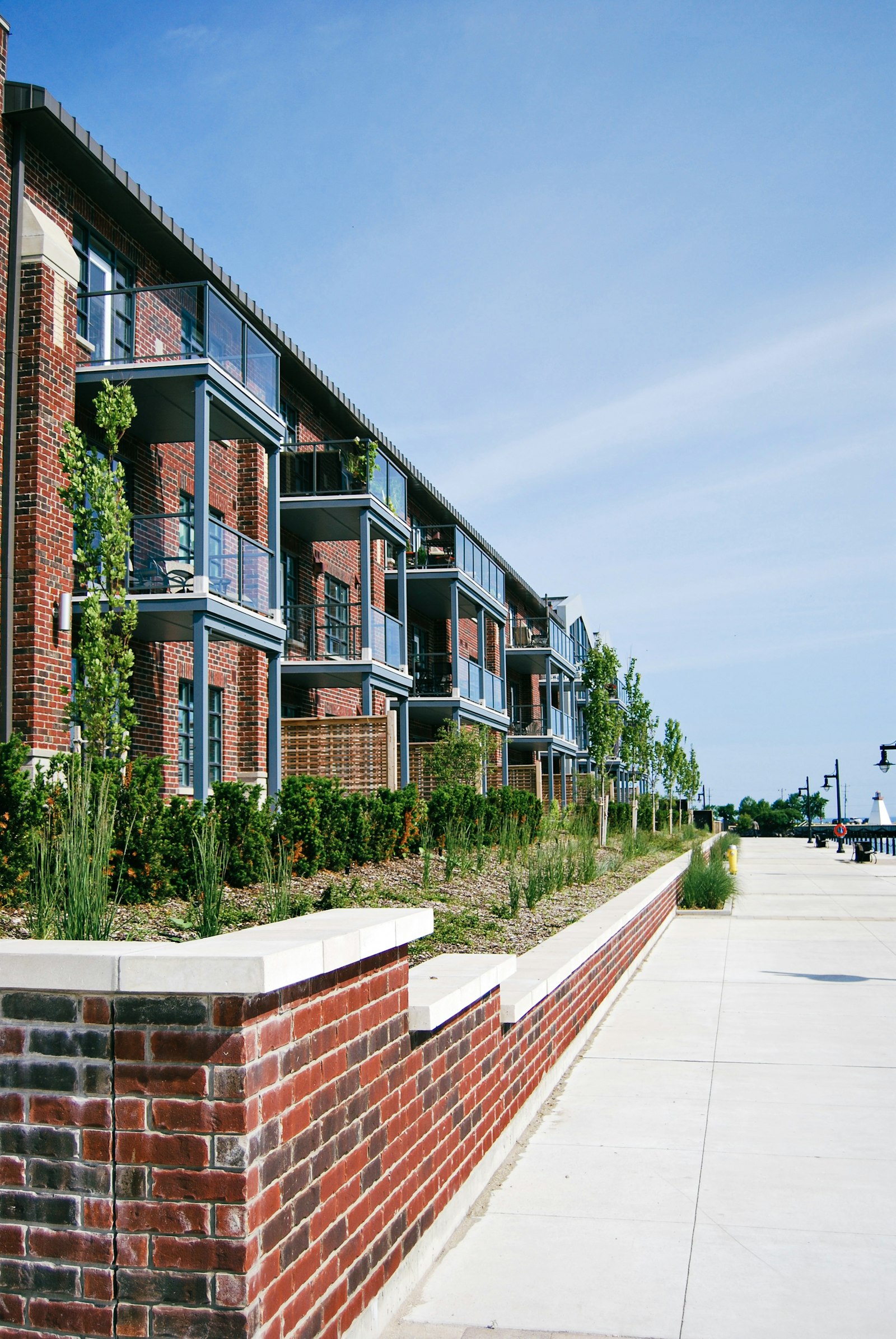 Brick apartment building with landscaped walkway on a sunny day